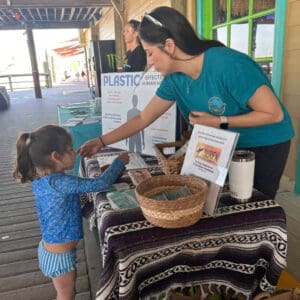 Photo of young girl at table about coastal community cleanup